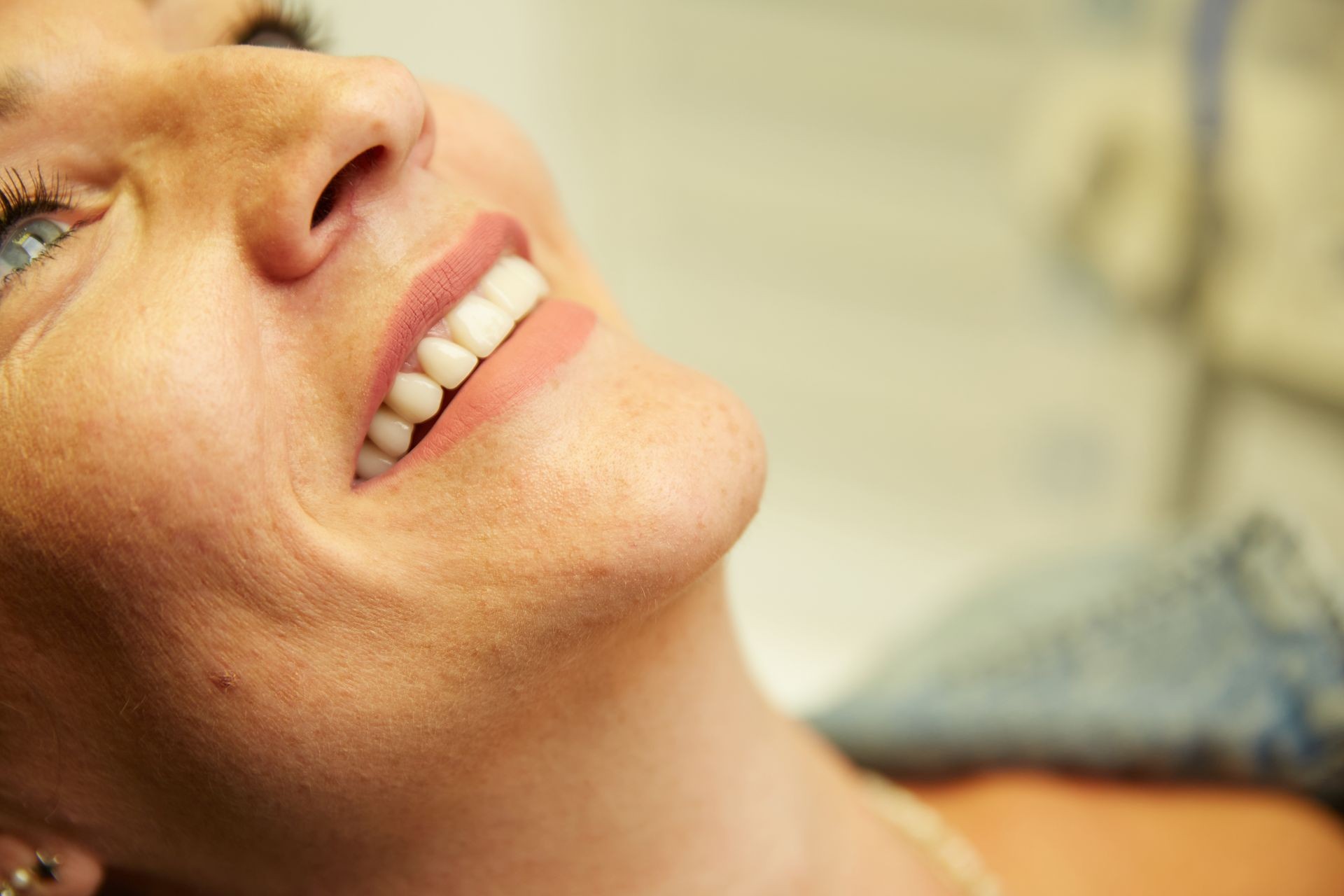 Close-up of a woman smiling, showing healthy white teeth and well-groomed lips.